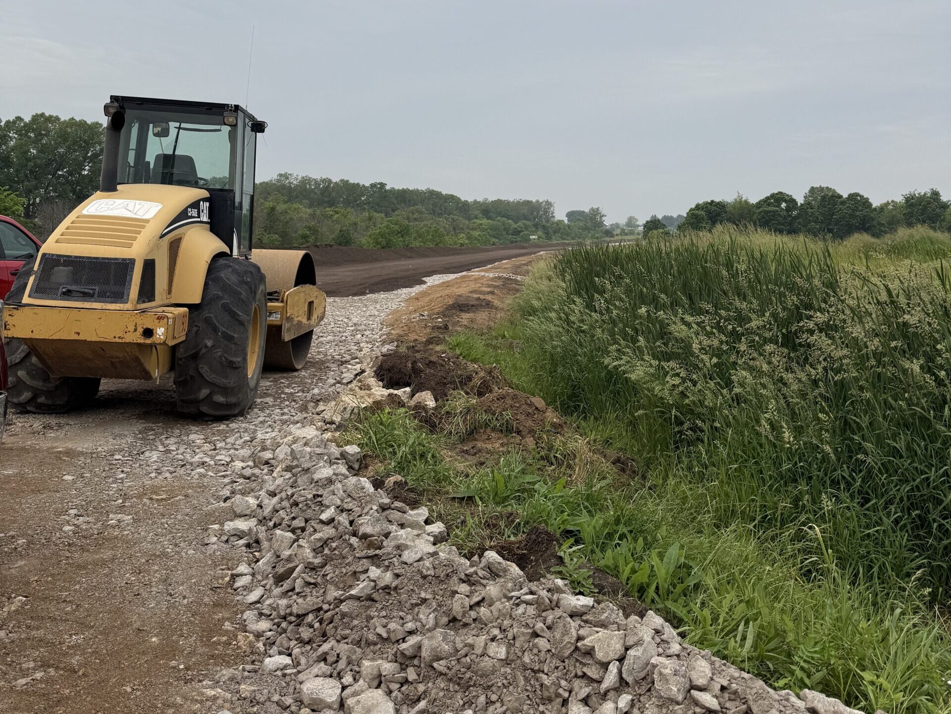 Ixonia Jobsite Ixoina Jobsite, Roller Sitting Ready for Work next to grassy field