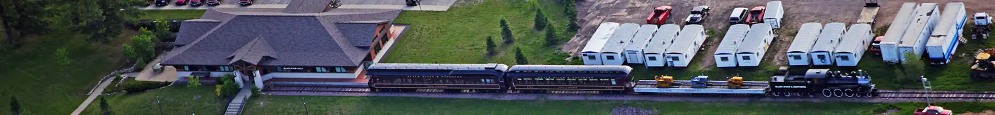 full-train-rail Drone's eye view of a train parked at a station.