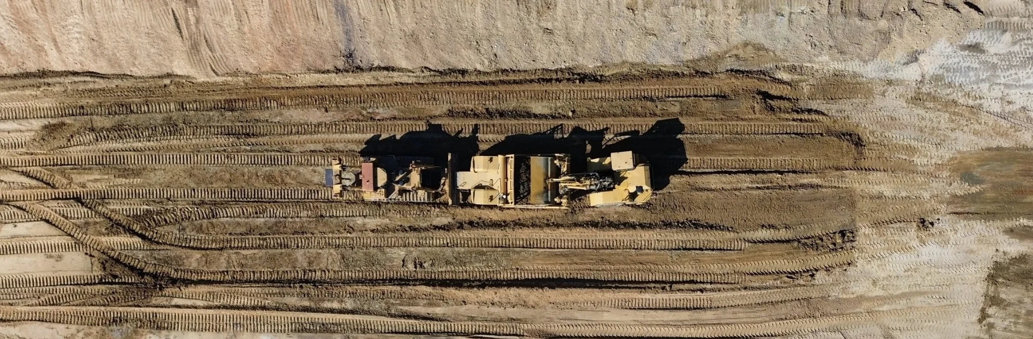 A wheel tractor scraper levels a section of a highway under construction
