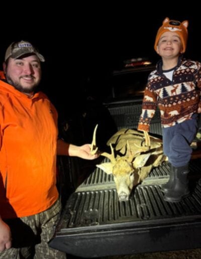Daniel and son with a buck in the truck