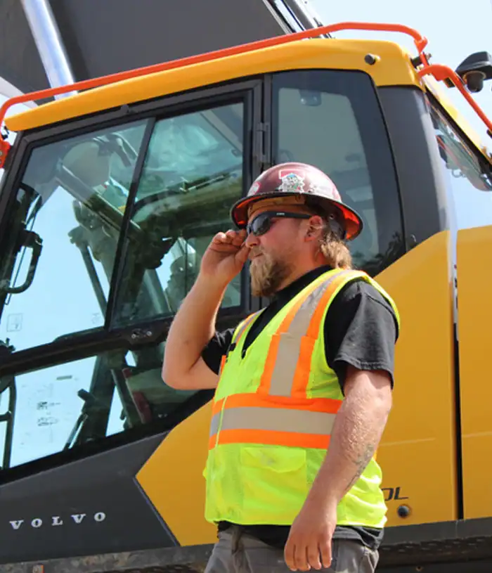 Two Hoffman Construction Employees On Chaska Jobsite in Safety Gear Standing Beside One Another