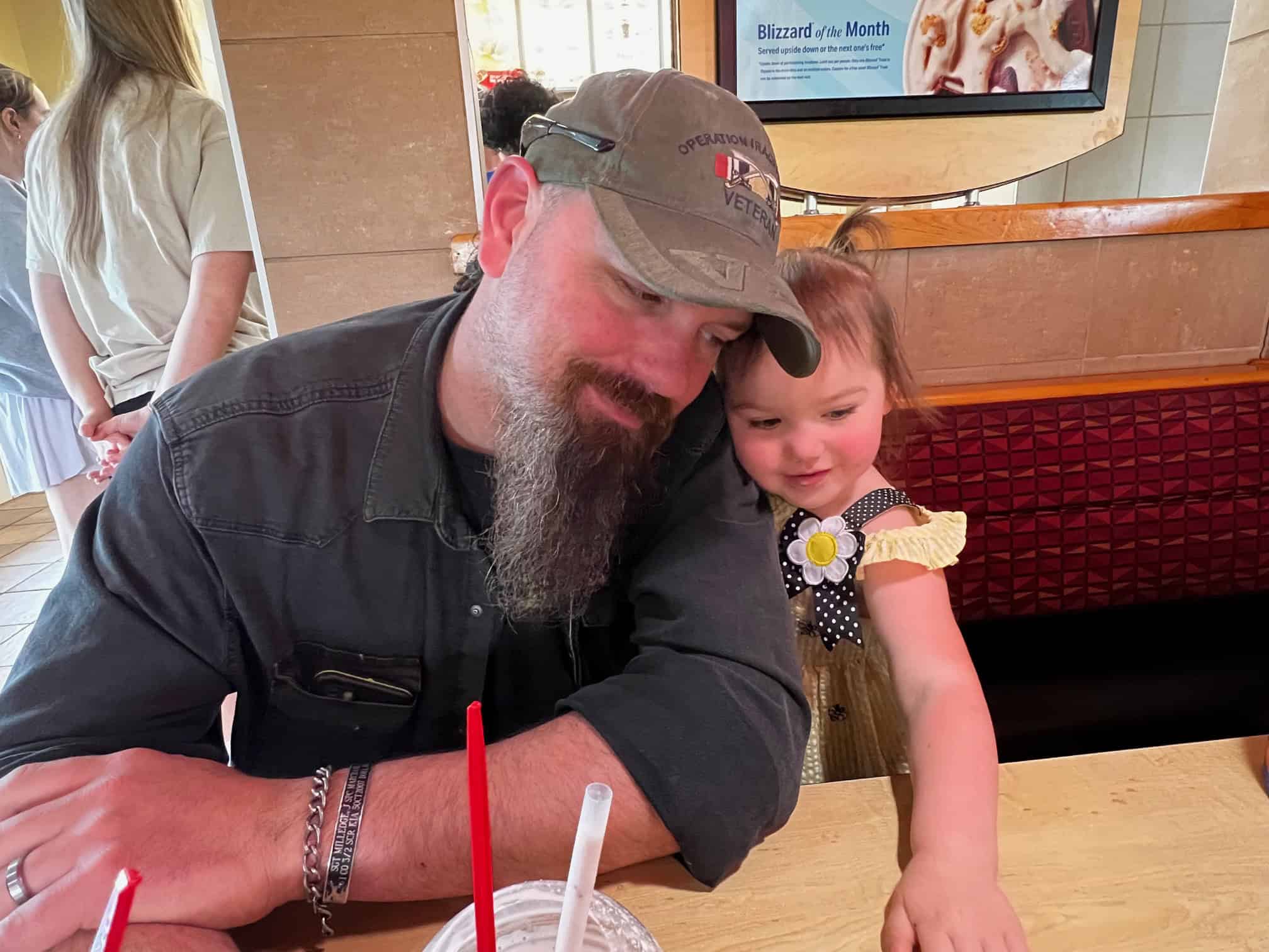 Tim and his Daughter Tim Hudson leaning on daughter in restaurant booth.